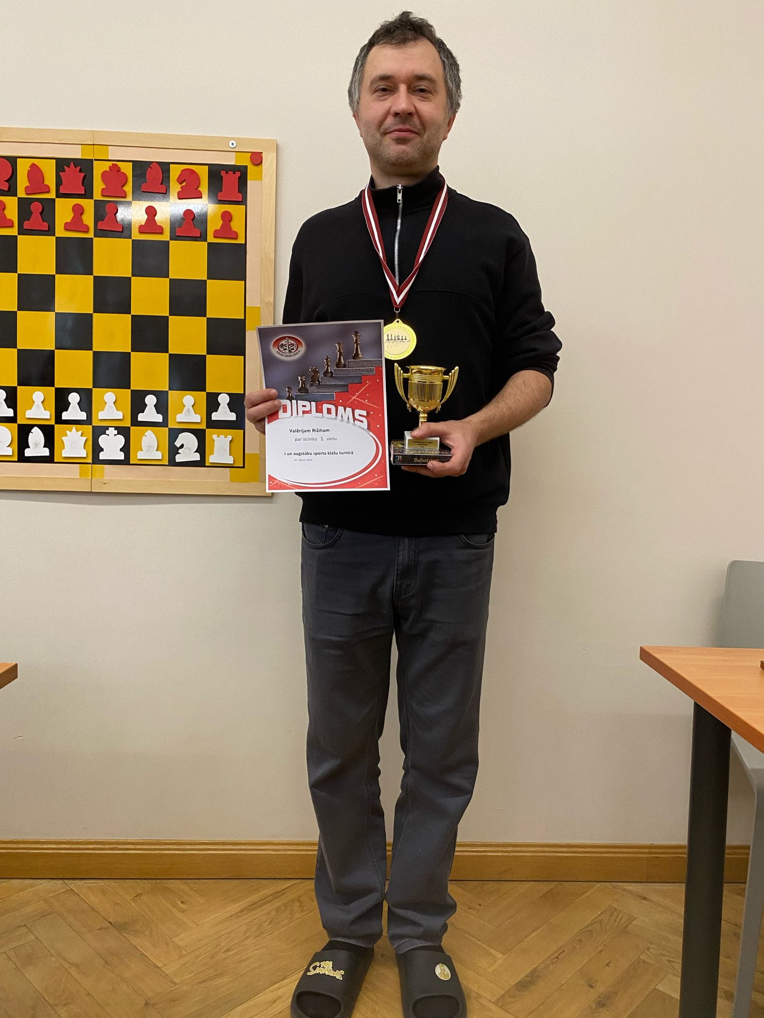 Šaha turnīra uzvarētājs ar kausu, medaļu un diplomu
