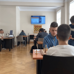 Cilvēki spēlē šahuu Rīgas Šaha skolas telpās