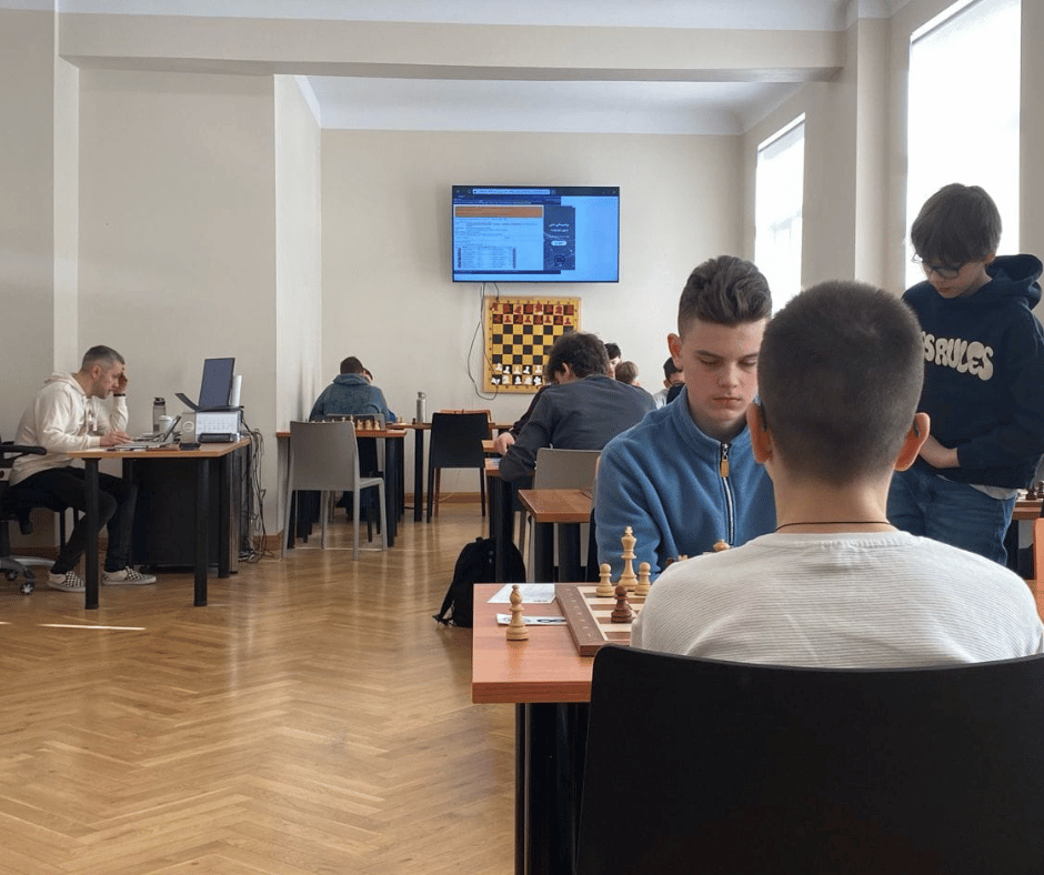 Cilvēki spēlē šahuu Rīgas Šaha skolas telpās